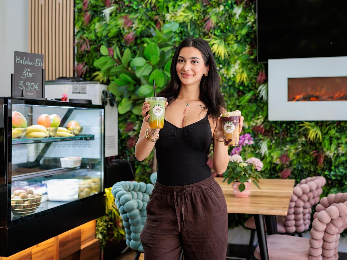 Im Palm & Berry Café: Matcha-Drink und Açaí Bowl vor der grünen Pflanzenwand